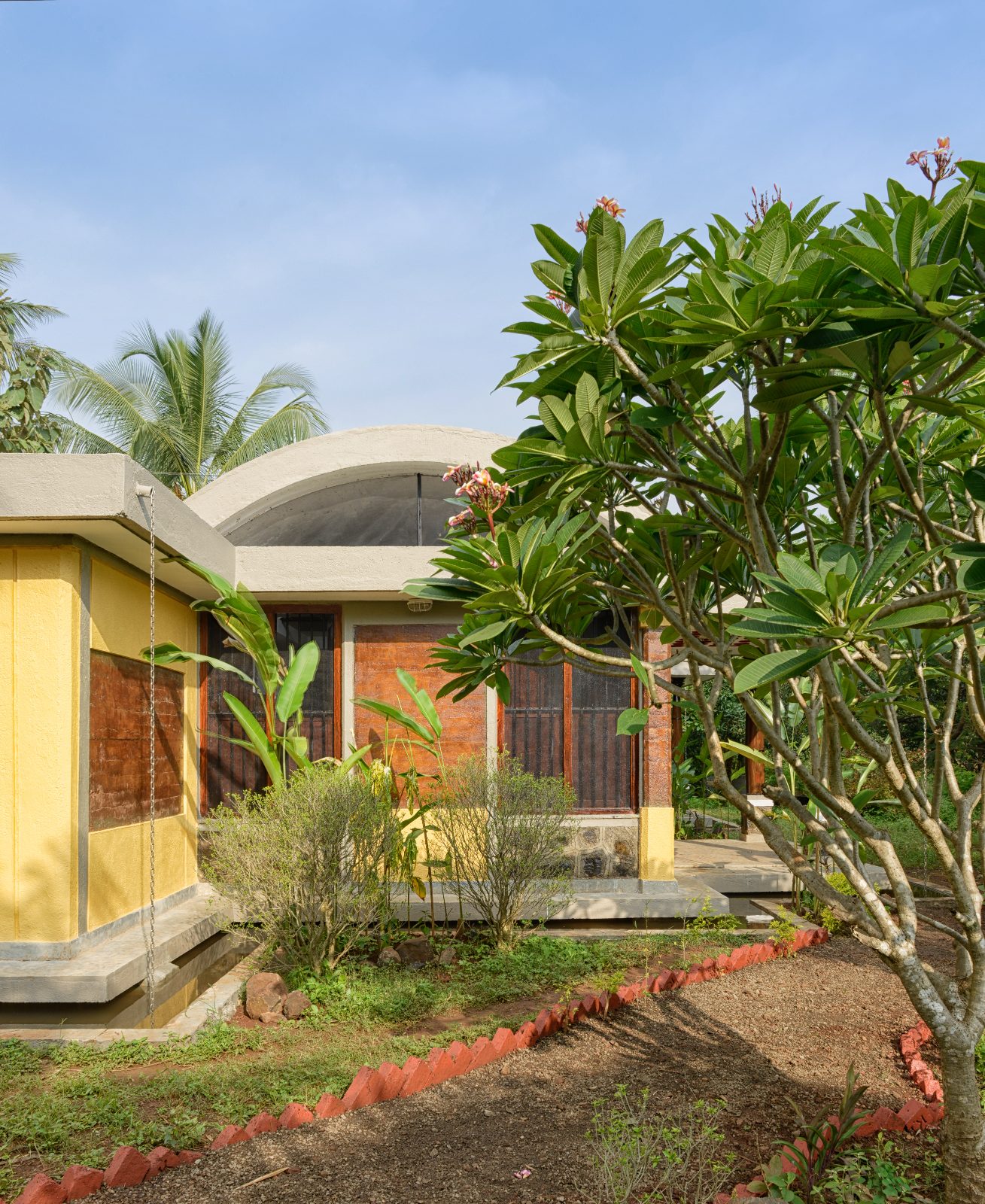 Rammed earth farm house, Thane, Mumbai: yellow vaulted farm house exterior, architectural photograph.